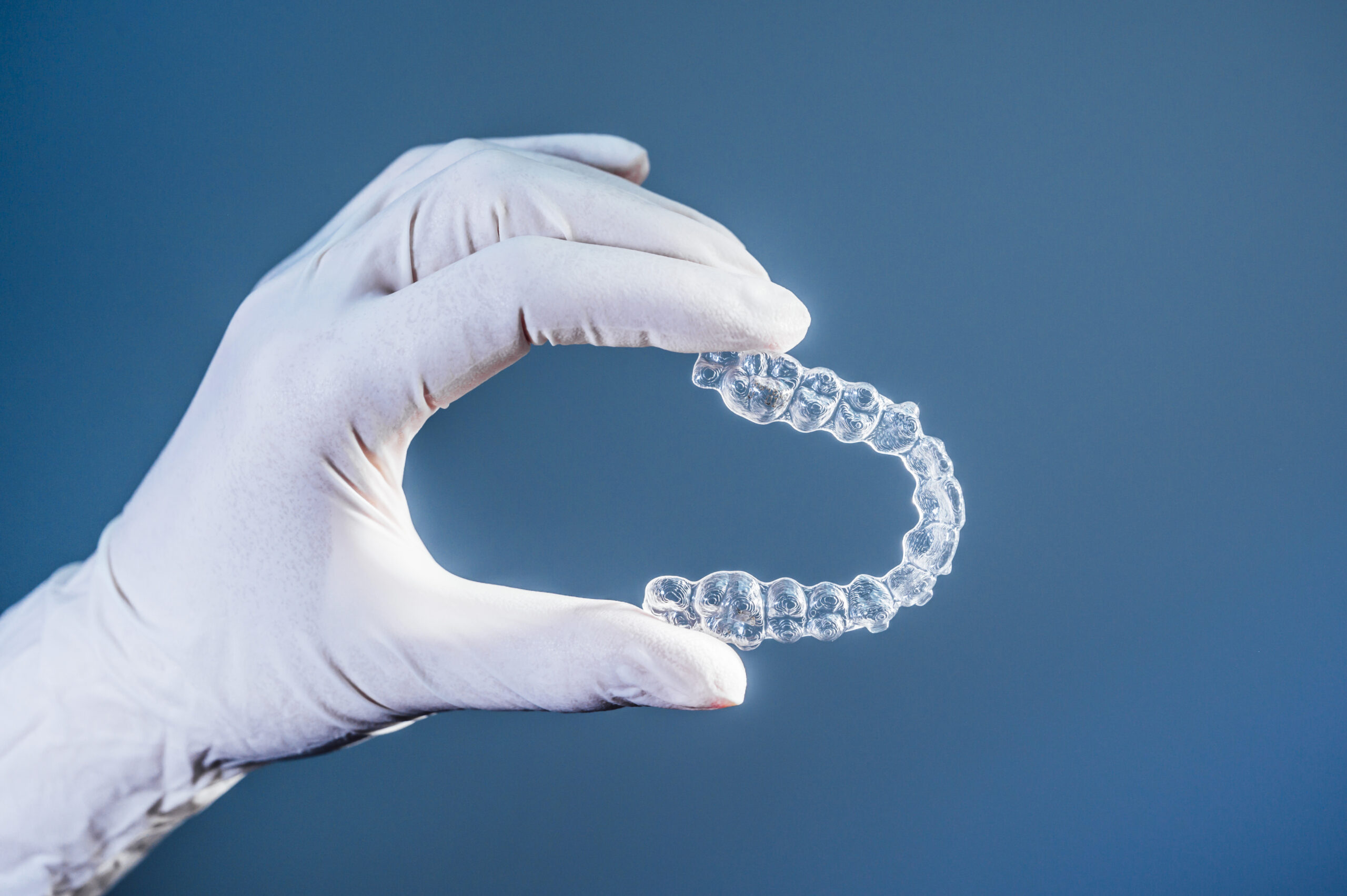 Doctor Hand Holding Clear Dental Aligner.jpg Scaled